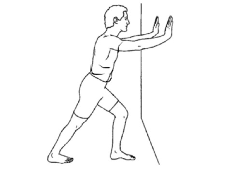 به فاصله یک دست از دیوار فاصله بگیرید پای آسیب دیده را نسبت به پای سالم عقب تر قرار دهید؛ سپس در حالی که کف دست ها را بر روی دیوار  و روبروی سینه قرار داده اید؛ به آرامی بدن را به دیوار نزدیک کنید، تا زمانی که در ناحیه ساق پا کشش احساس شود،  در این وضعیت ۱۵ تا ۳۰ ثانیه بمانید، سپس به موقعیت اول برگردید. این حرکت را ۲ بار تکرار کنید. می توانید در طول روز این حرکت را چند بار تکرار کنید.